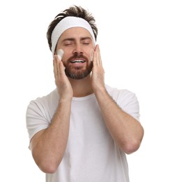 Man with headband washing his face on white background