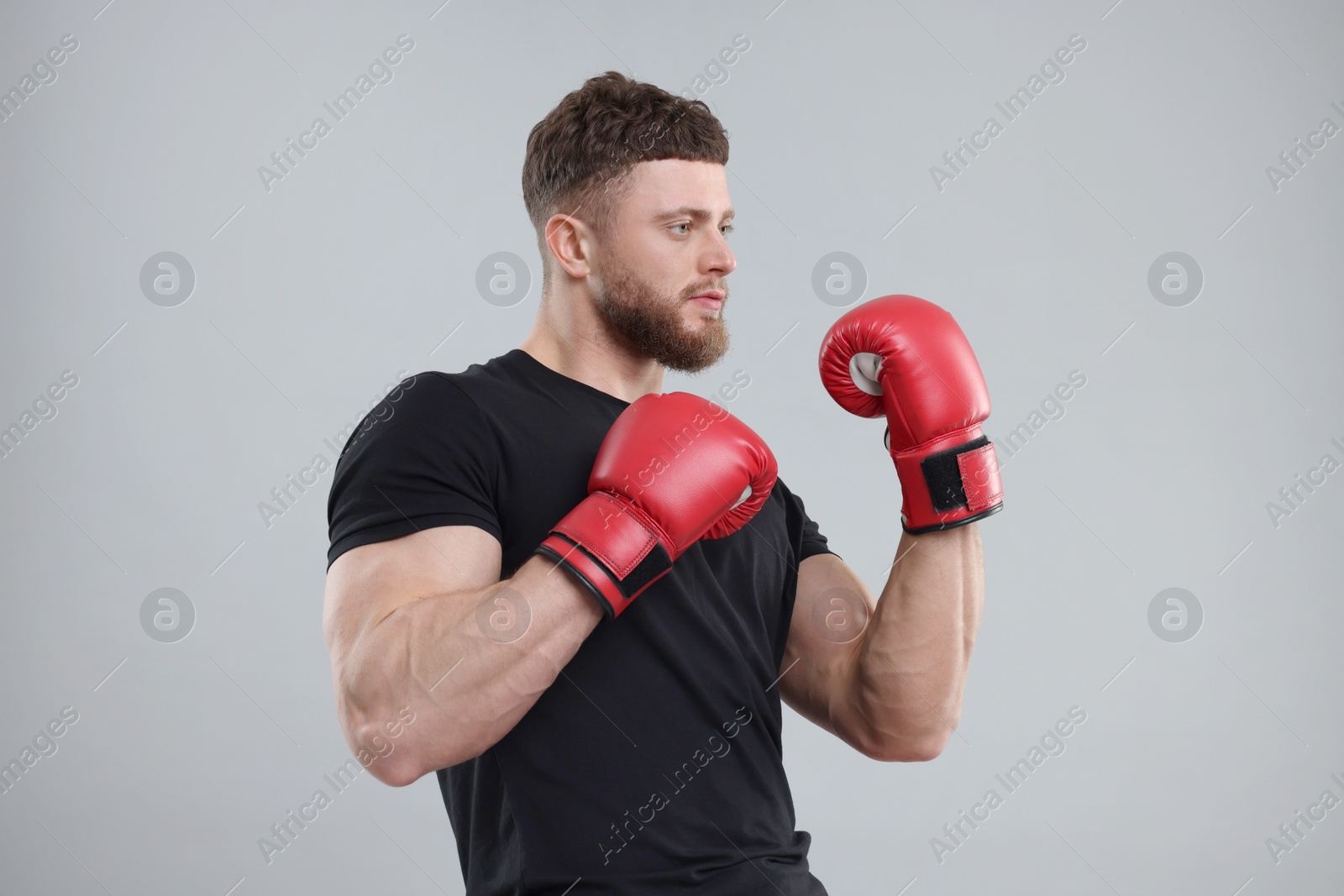 Photo of Man in boxing gloves on grey background