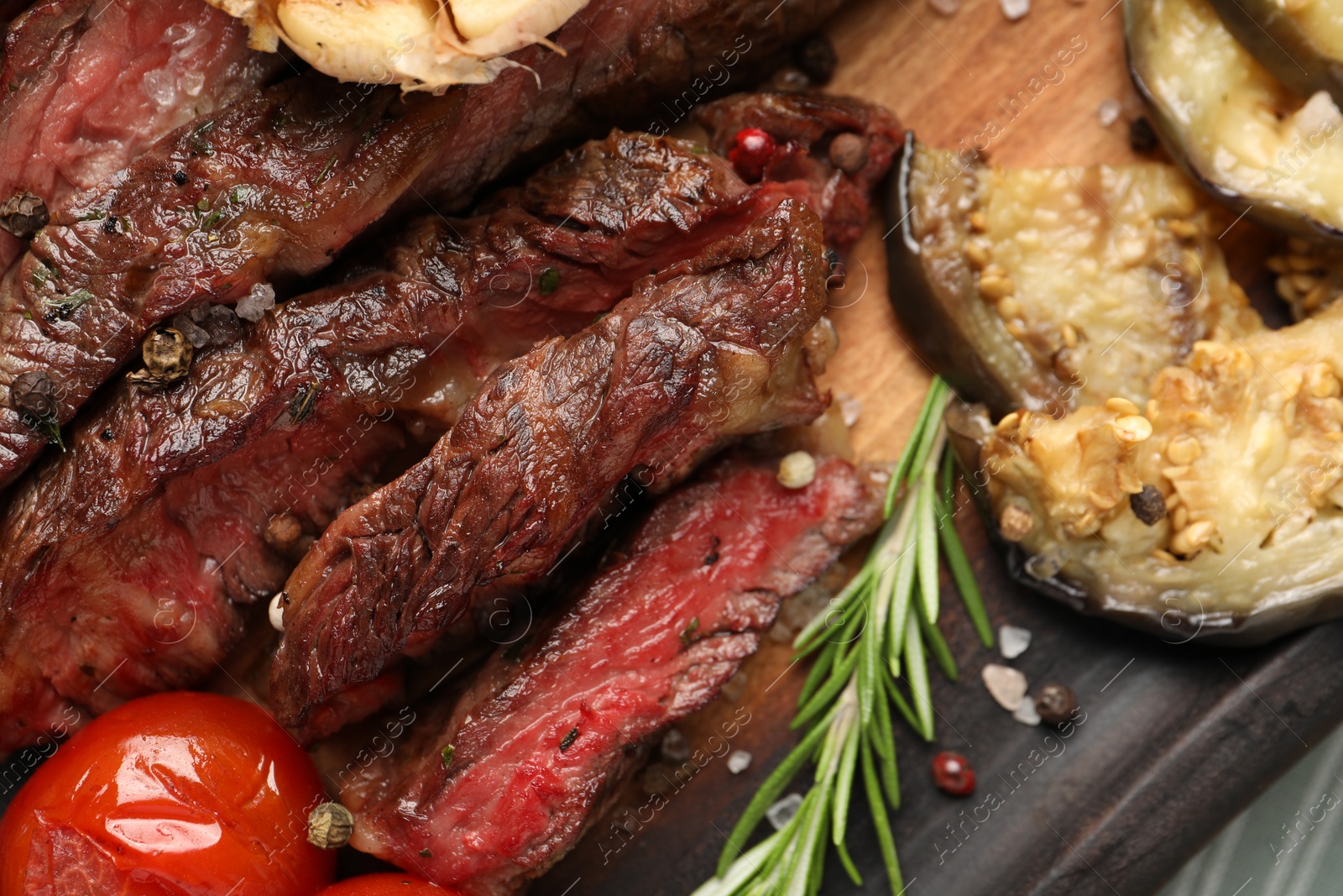 Photo of Delicious grilled beef steak with vegetables and spices on table, top view