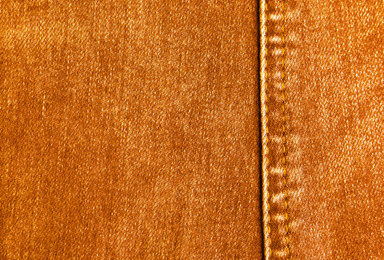 Texture of orange jeans as background, closeup