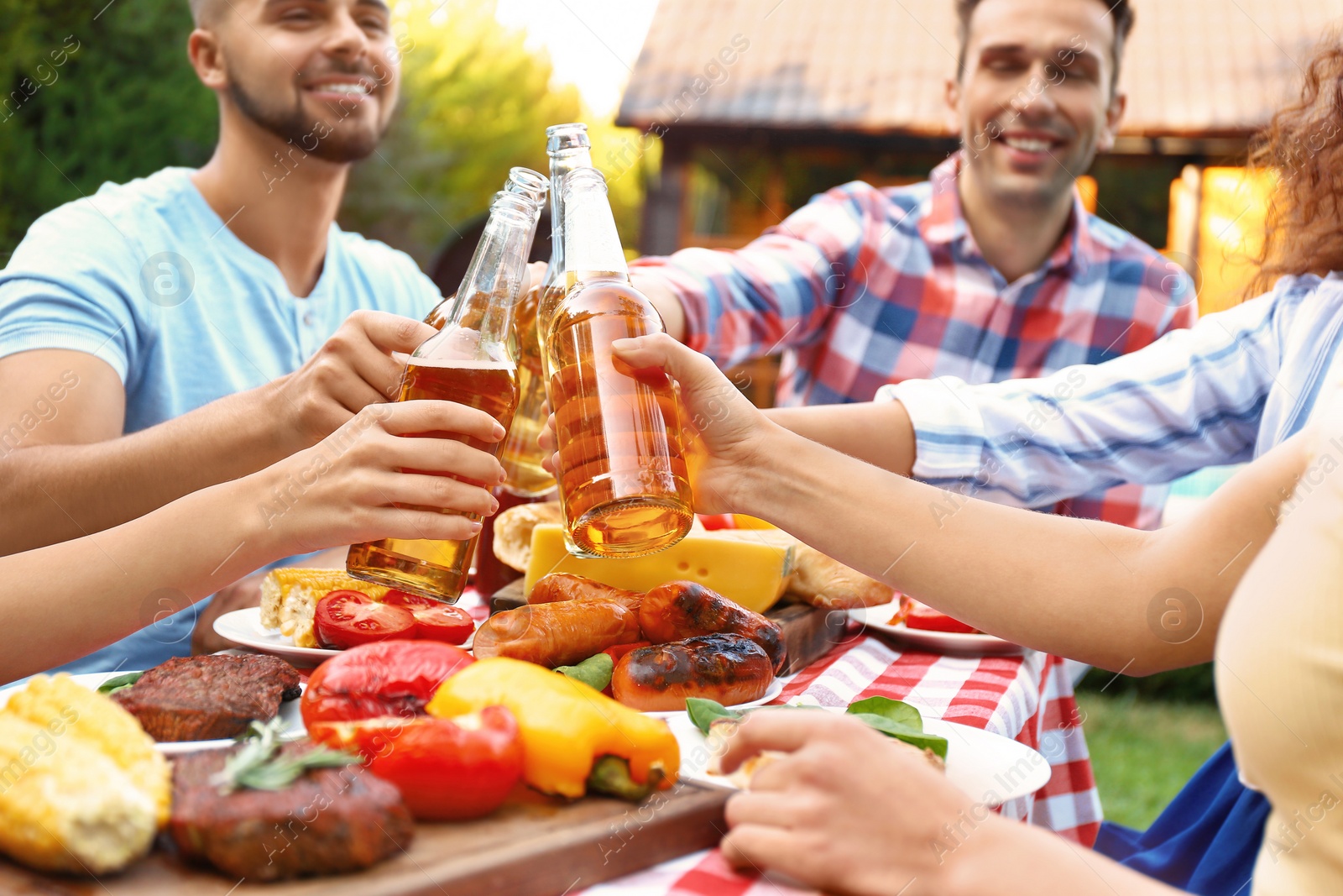 Photo of Happy friends with drinks having fun at barbecue party outdoors