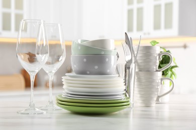 Photo of Many different clean dishware, glasses, cups and cutlery on white marble table indoors