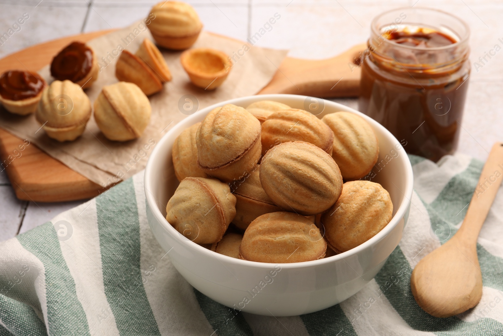 Photo of Delicious nut shaped cookies with boiled condensed milk on table, closeup