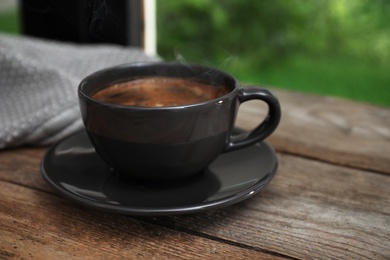 Cup of hot coffee on wooden table