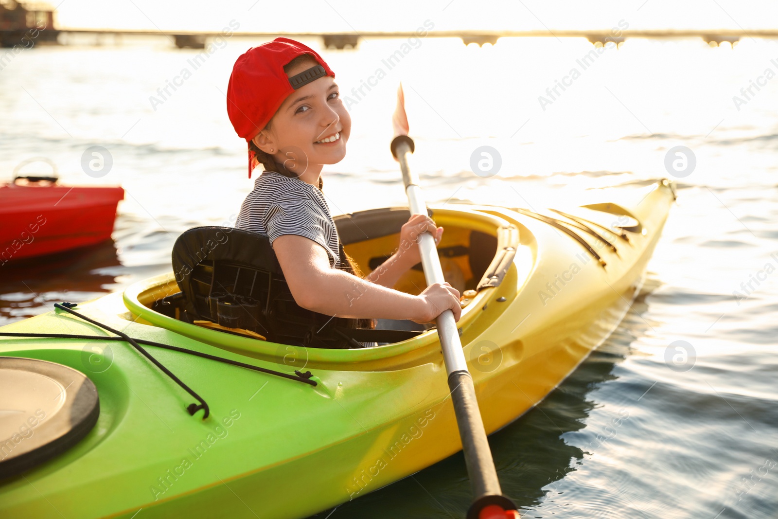 Photo of Happy little girl kayaking on river. Summer camp activity