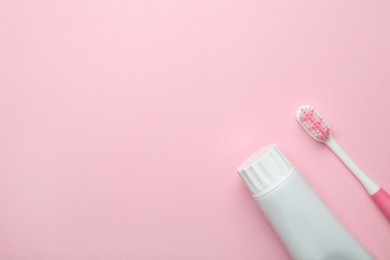 Photo of Blank tube of toothpaste and brush on color background, top view with space for text