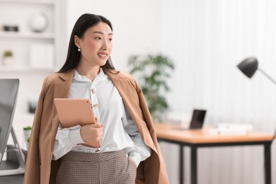 Photo of Portrait of smiling businesswoman with tablet in office. Space for text