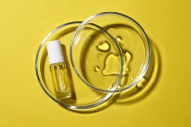 Photo of Petri dishes with bottle on yellow background, top view
