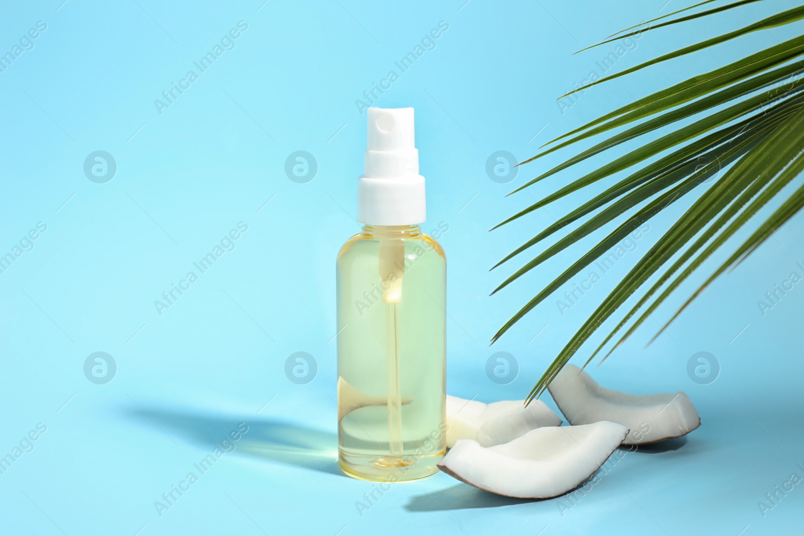 Photo of Aromatic coconut oil on light blue background