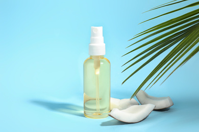 Photo of Aromatic coconut oil on light blue background