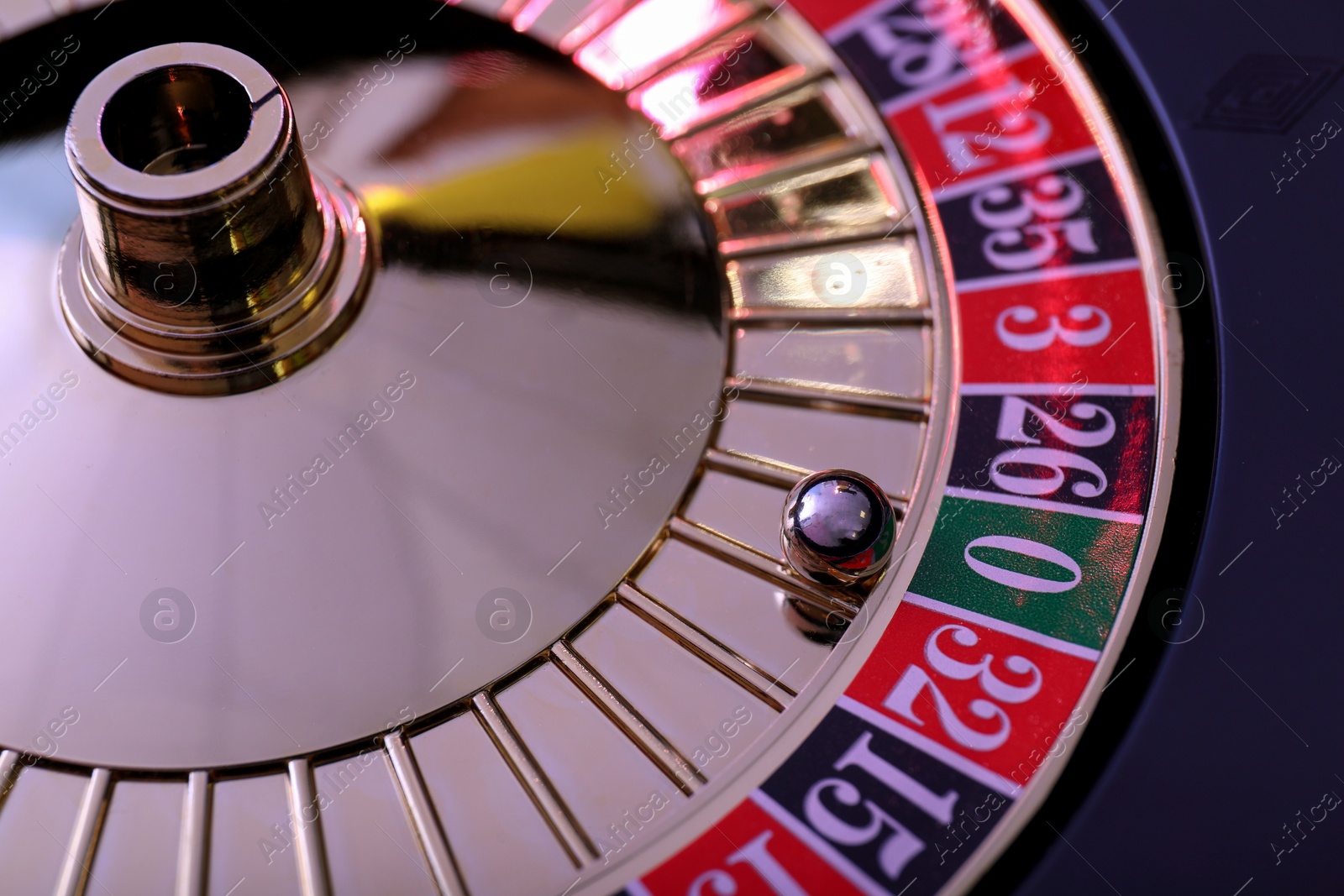 Photo of Roulette wheel with ball, closeup. Casino game