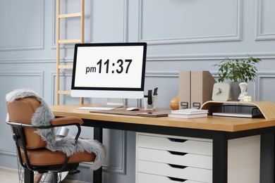 Photo of Stylish workplace with computer, houseplant and stationery on wooden desk near grey wall at home