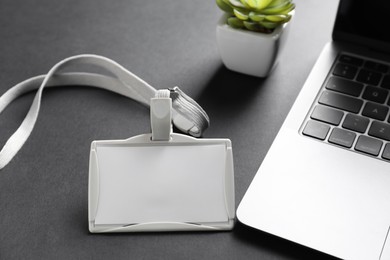 Photo of Blank badge, laptop and houseplant on grey background