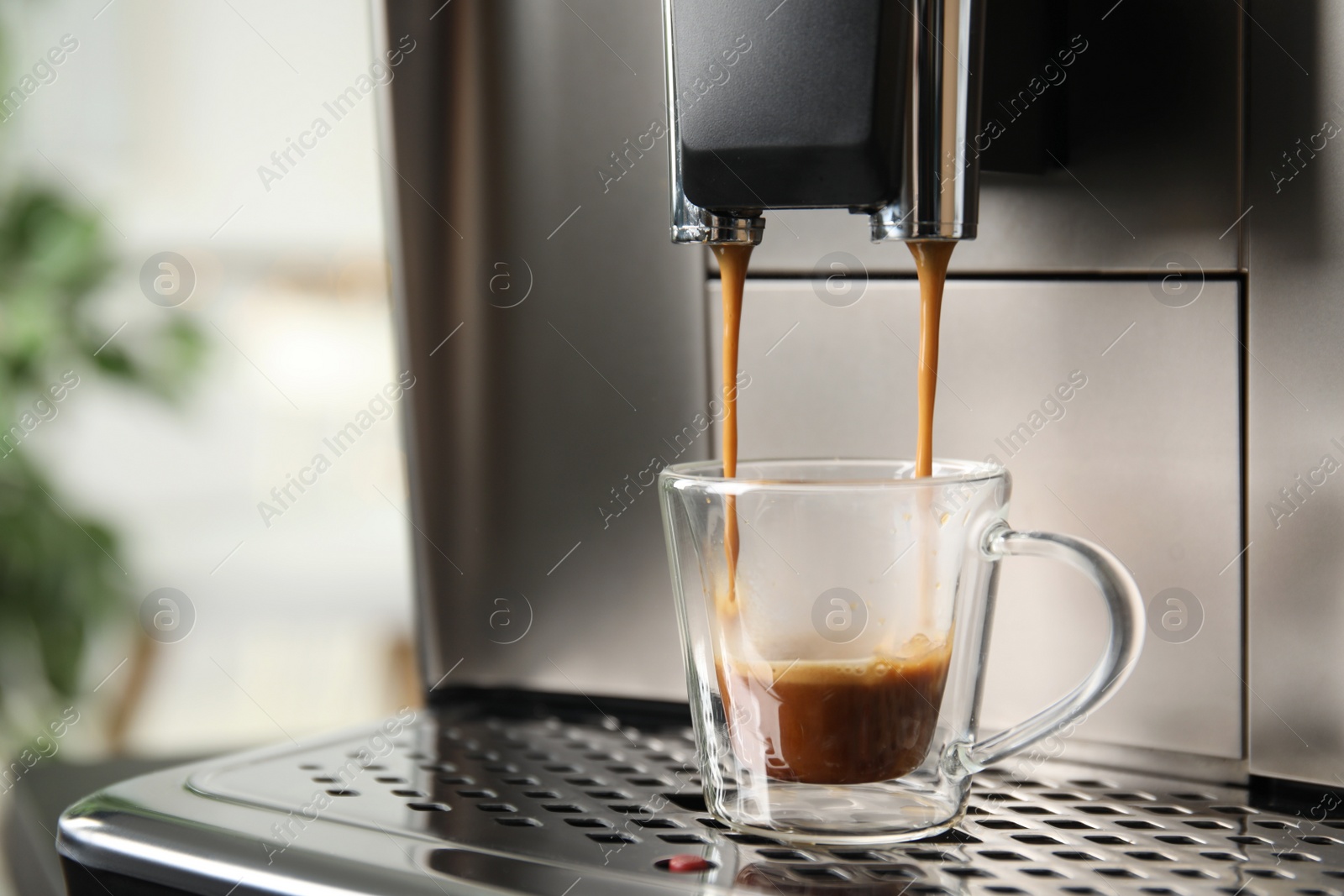 Photo of Espresso machine pouring coffee into glass cup against blurred background, closeup. Space for text