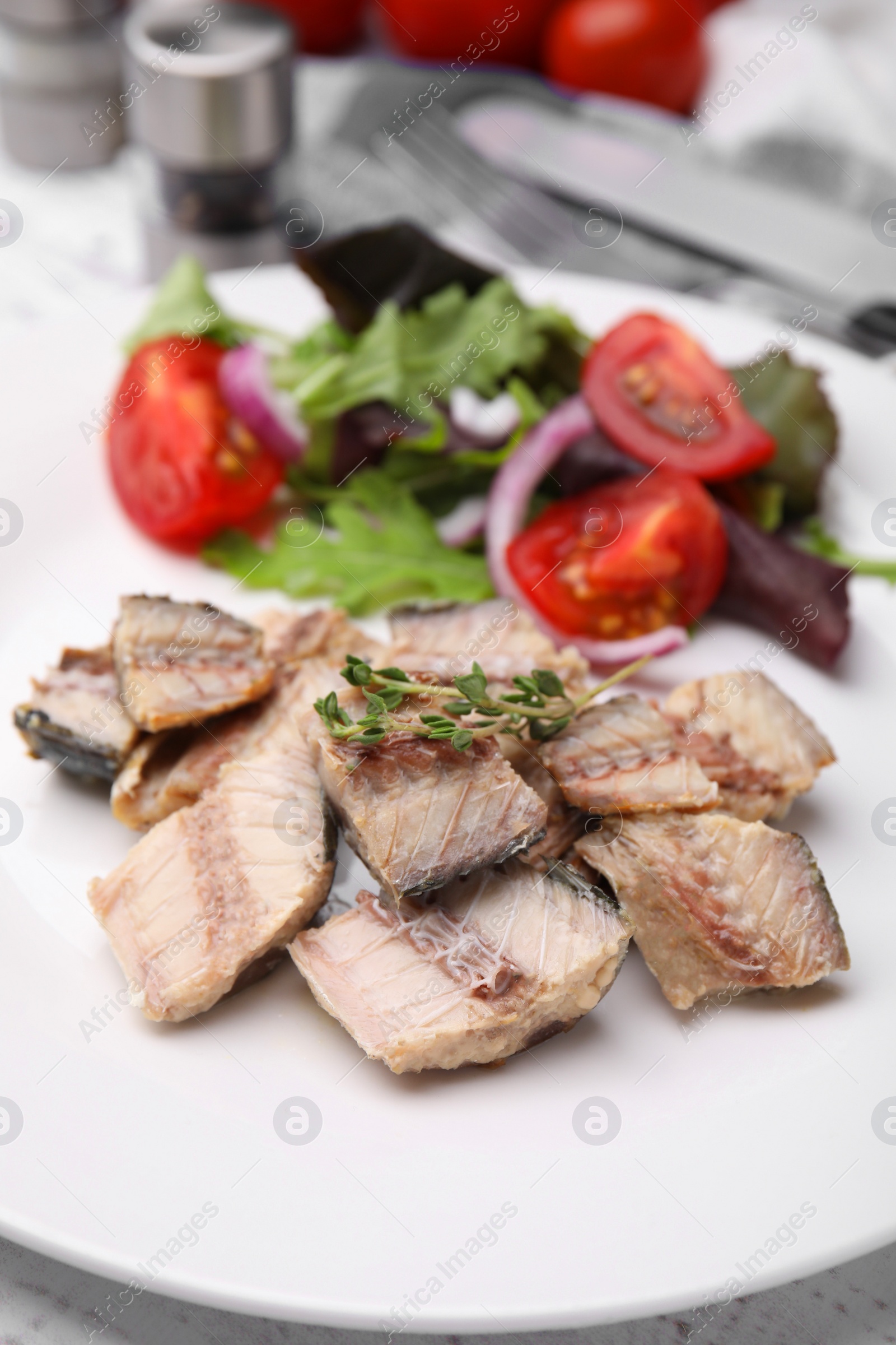 Photo of Delicious canned mackerel chunks served on white table, closeup