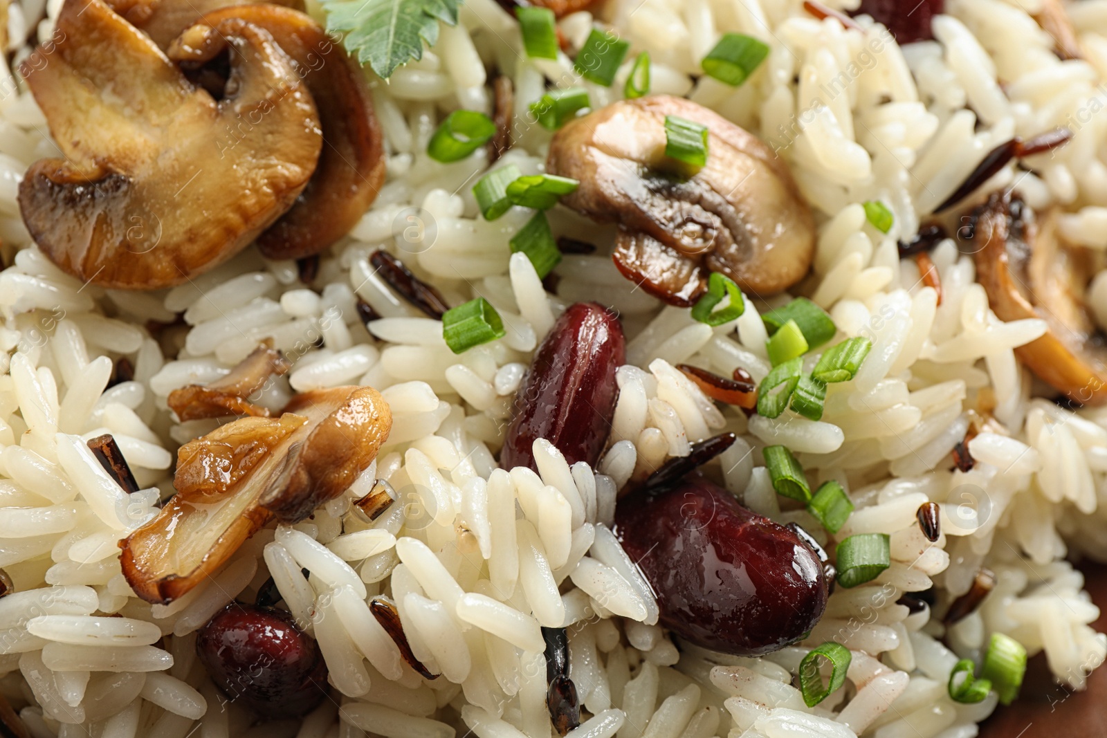 Photo of Delicious rice pilaf with beans and mushrooms as background, closeup