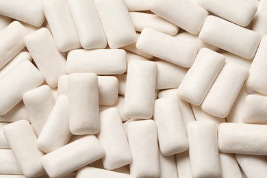 Photo of Many chewing gum pieces as background, top view
