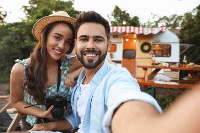 Photo of Young travelers with camera taking selfie outdoors. Summer trip