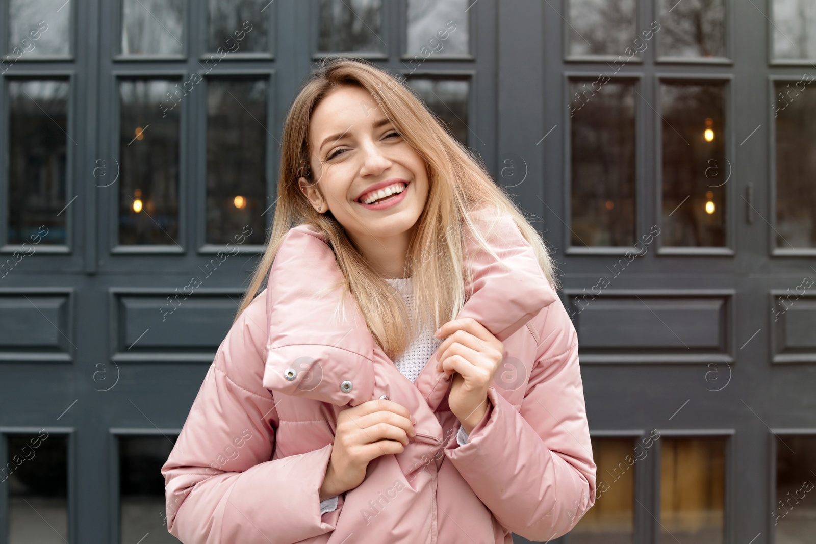 Photo of Happy young woman in warm jacket outdoors