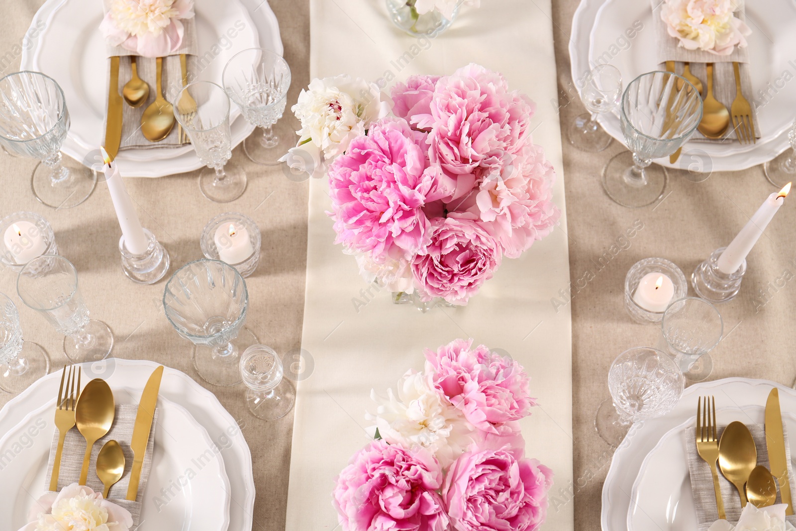 Photo of Stylish table setting with beautiful peonies and burning candles, above view