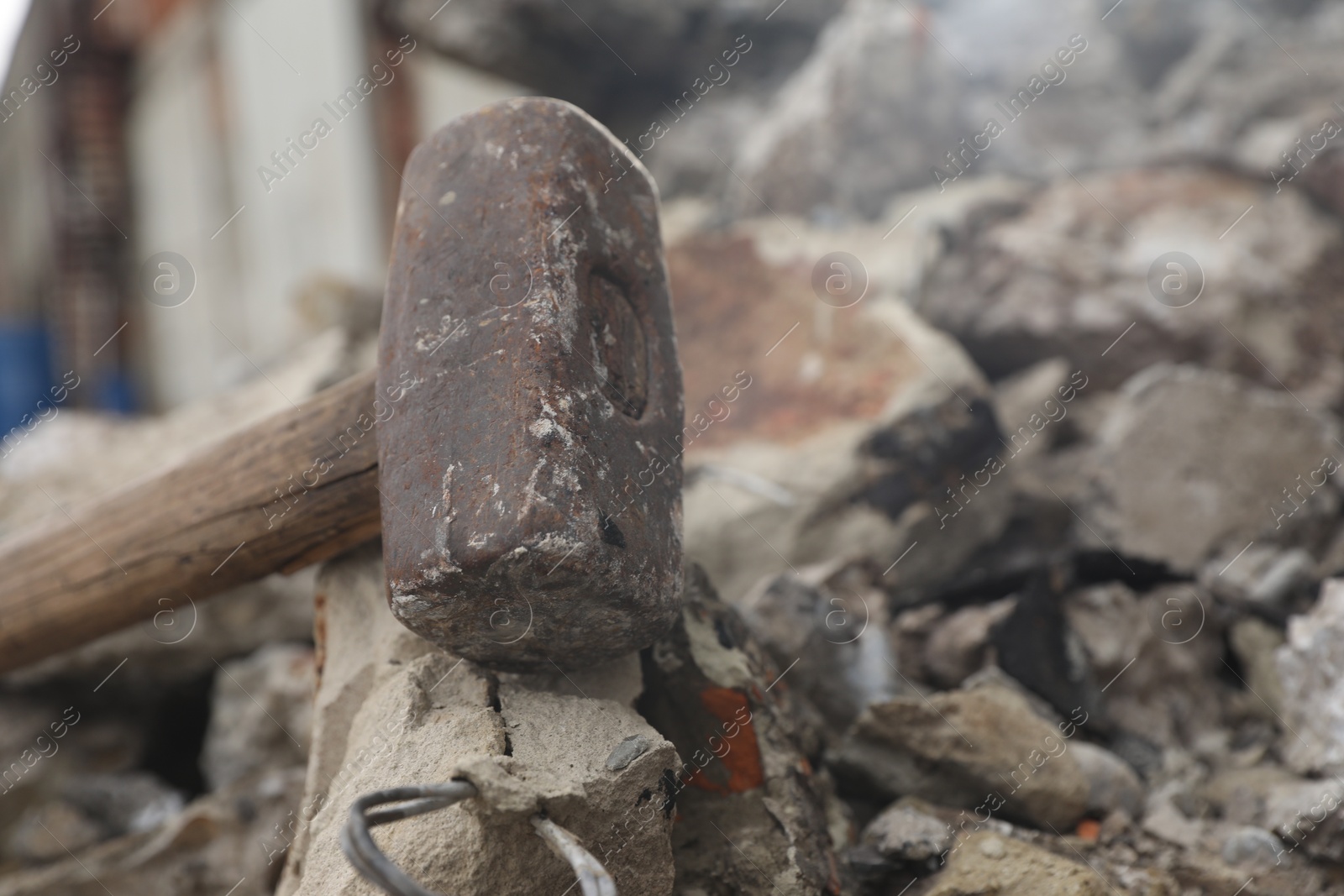 Photo of Sledgehammer on pile of broken stones outdoors, closeup