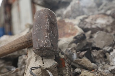 Sledgehammer on pile of broken stones outdoors, closeup