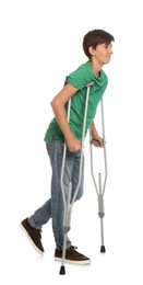 Teenage boy with injured leg using crutches on white background