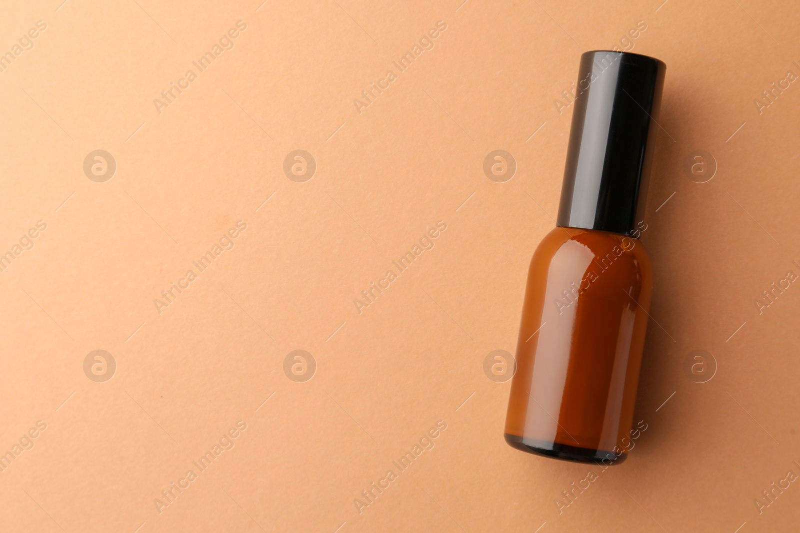 Photo of Bottle of face cream on beige background, top view. Space for text