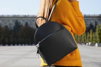 Photo of Woman with stylish black backpack on city street, closeup