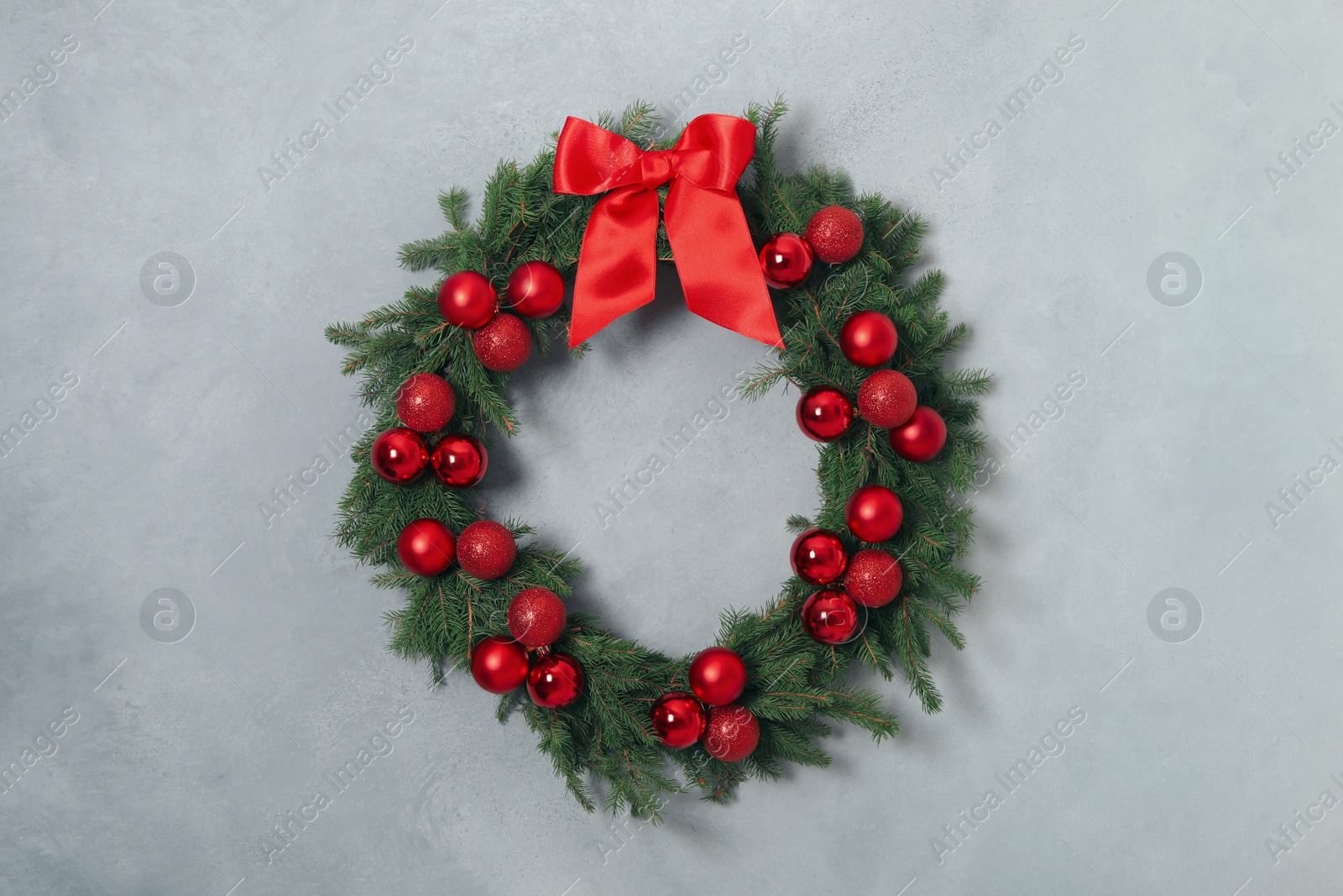 Photo of Beautiful Christmas wreath with festive decor on light grey wall