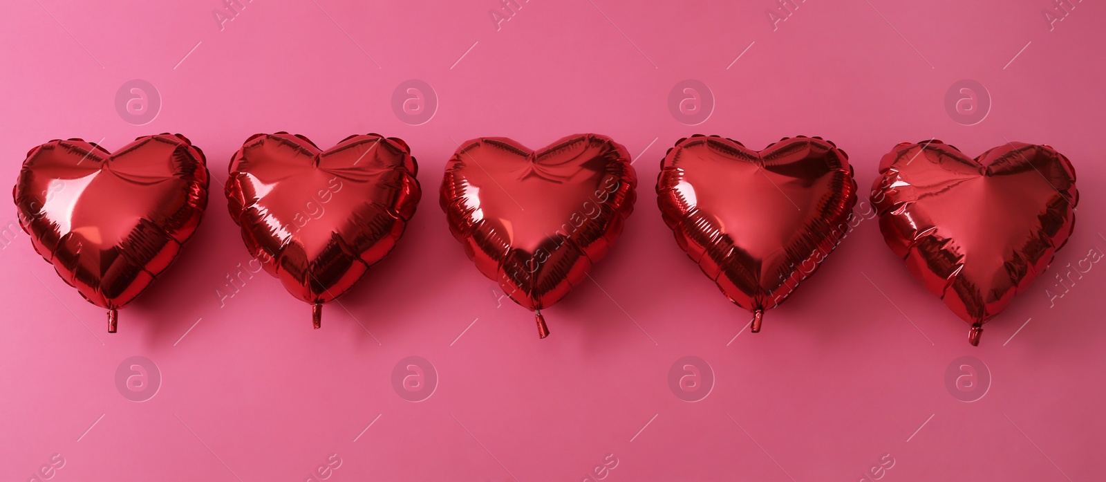 Photo of Red heart shaped balloons on pink background, flat lay. Saint Valentine's day celebration