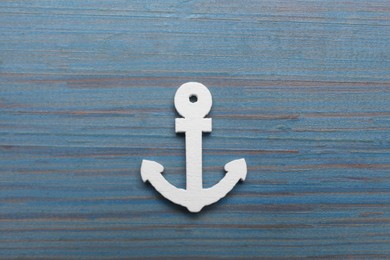 Anchor figure on light blue wooden table, top view