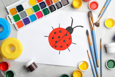 Photo of Flat lay composition with child's painting of ladybug on marble table