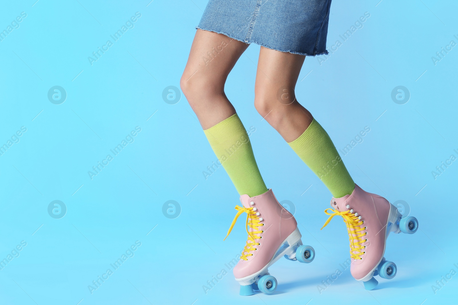 Photo of Woman with vintage roller skates on color background, closeup. Space for text