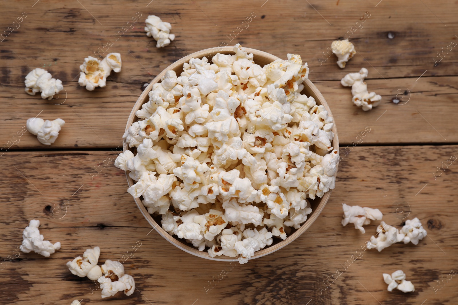 Photo of Tasty popcorn on wooden table, flat lay