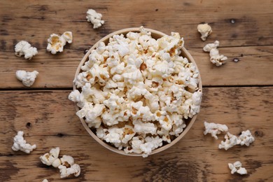 Photo of Tasty popcorn on wooden table, flat lay