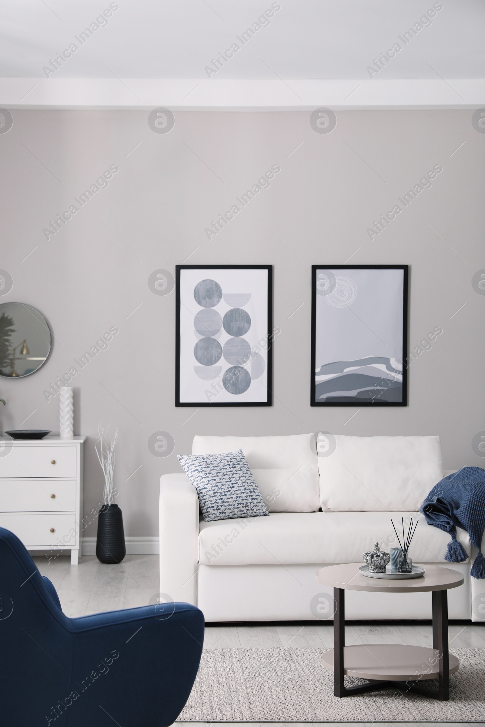 Photo of Stylish living room interior with white sofa, armchair and small coffee table