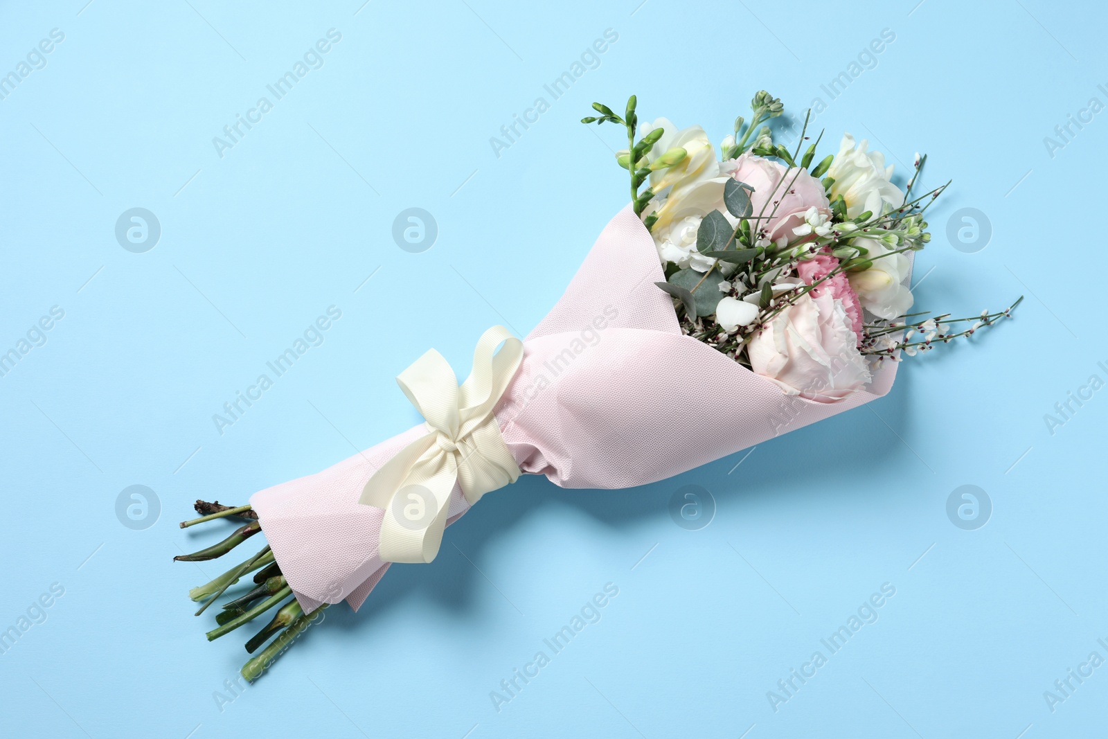 Photo of Bouquet of beautiful flowers on light blue background, top view