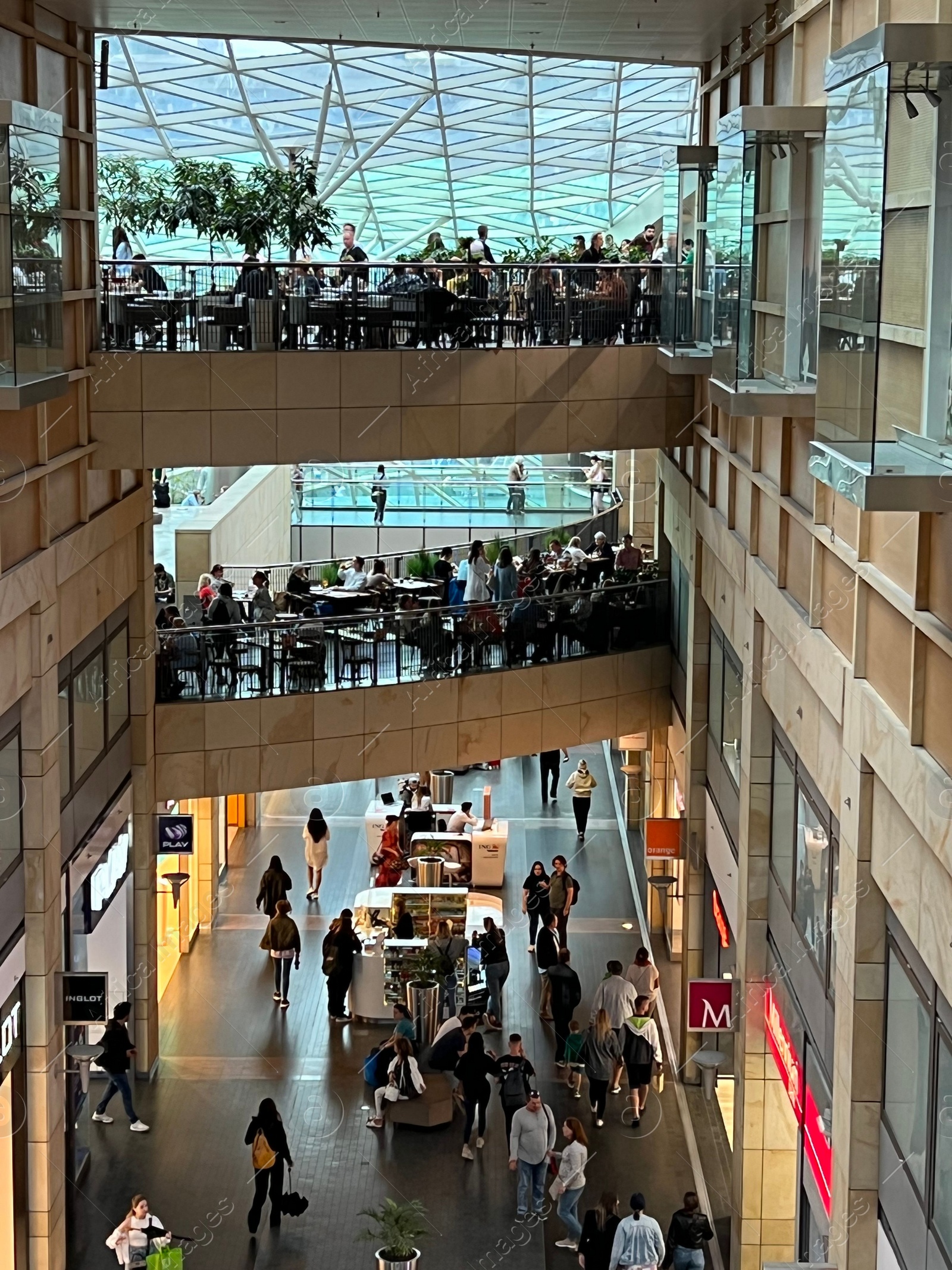 Photo of WARSAW, POLAND - JULY 17, 2022: Big shopping mall with many stores and customers