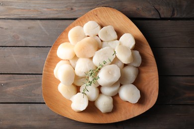 Fresh raw scallops and thyme on wooden table, top view