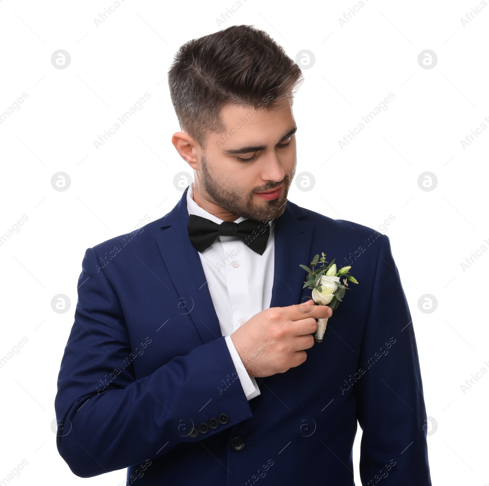 Photo of Handsome young groom with boutonniere on white background. Wedding accessory