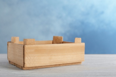 Photo of Wooden crate on table against color background. Space for text