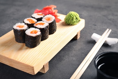 Photo of Tasty sushi rolls served on grey table. Food delivery