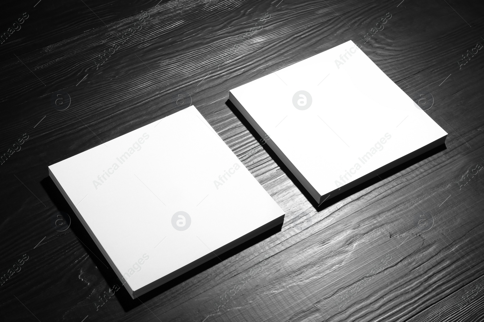 Photo of Blank paper sheets for brochure on black wooden background. Mock up