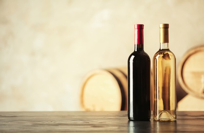 Bottles of delicious wine and blurred barrels on background