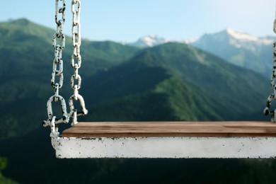 Photo of Outdoor metal swing in beautiful mountains on sunny day, closeup