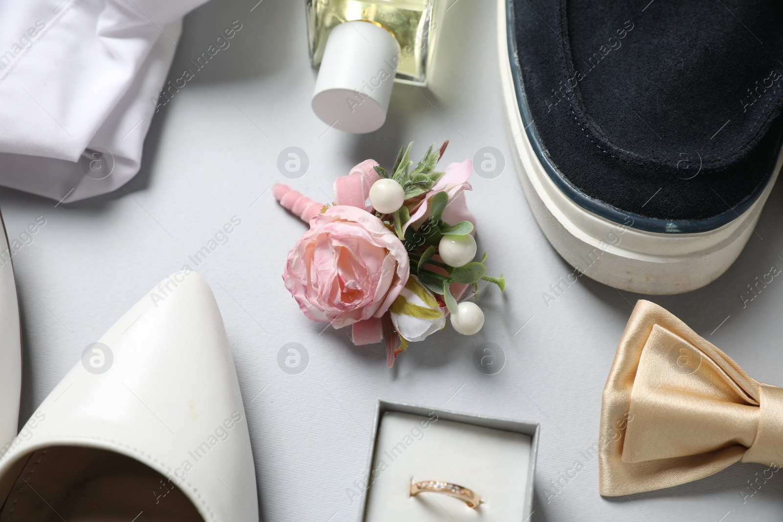 Photo of Wedding stuff. Composition with stylish boutonniere on light gray background, closeup