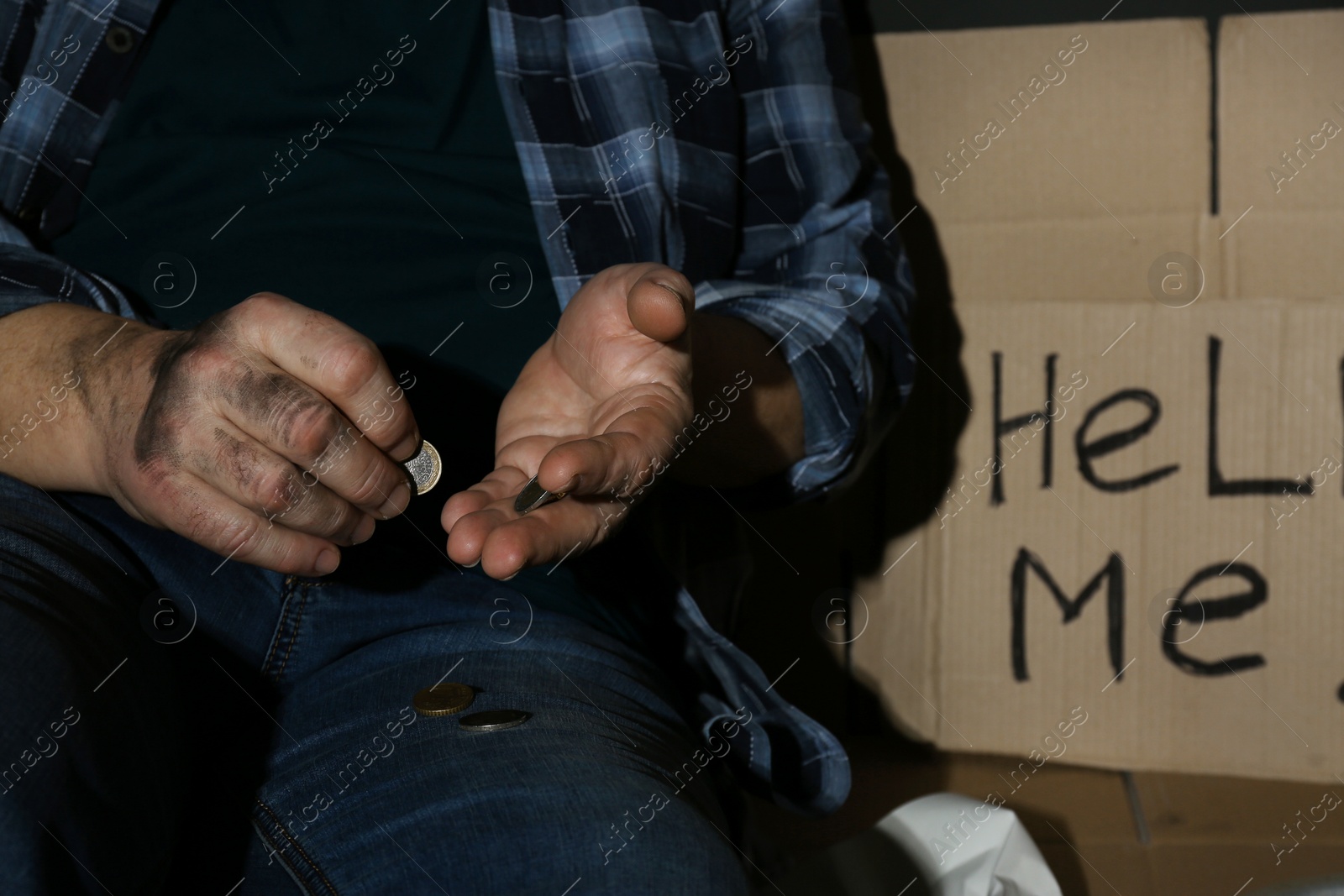 Photo of Poor senior man counting coins near cardboard sign HELP ME, closeup