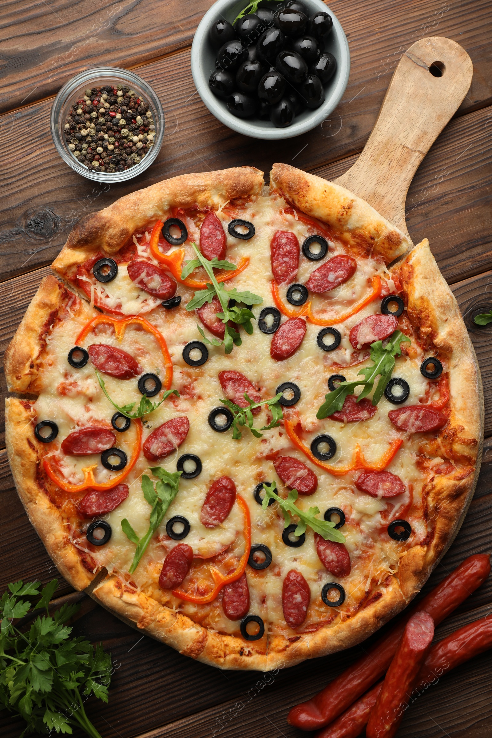 Photo of Tasty pizza and ingredients on wooden table, top view