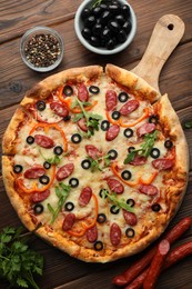 Photo of Tasty pizza and ingredients on wooden table, top view